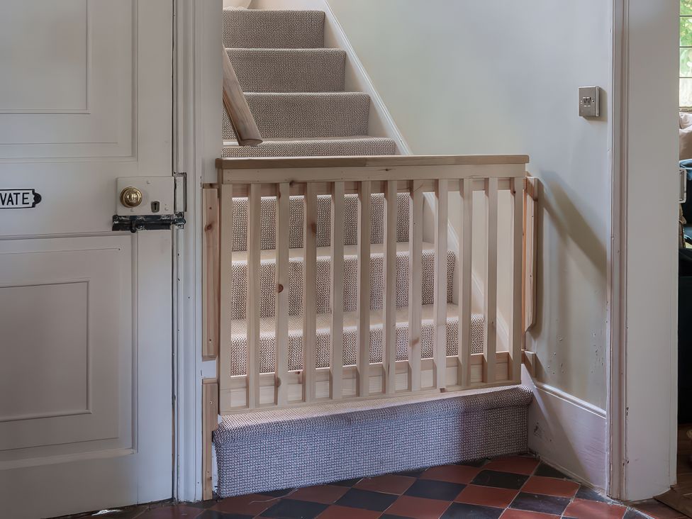 A staircase with a wooden gate and a door at Reybridge House in Lacock