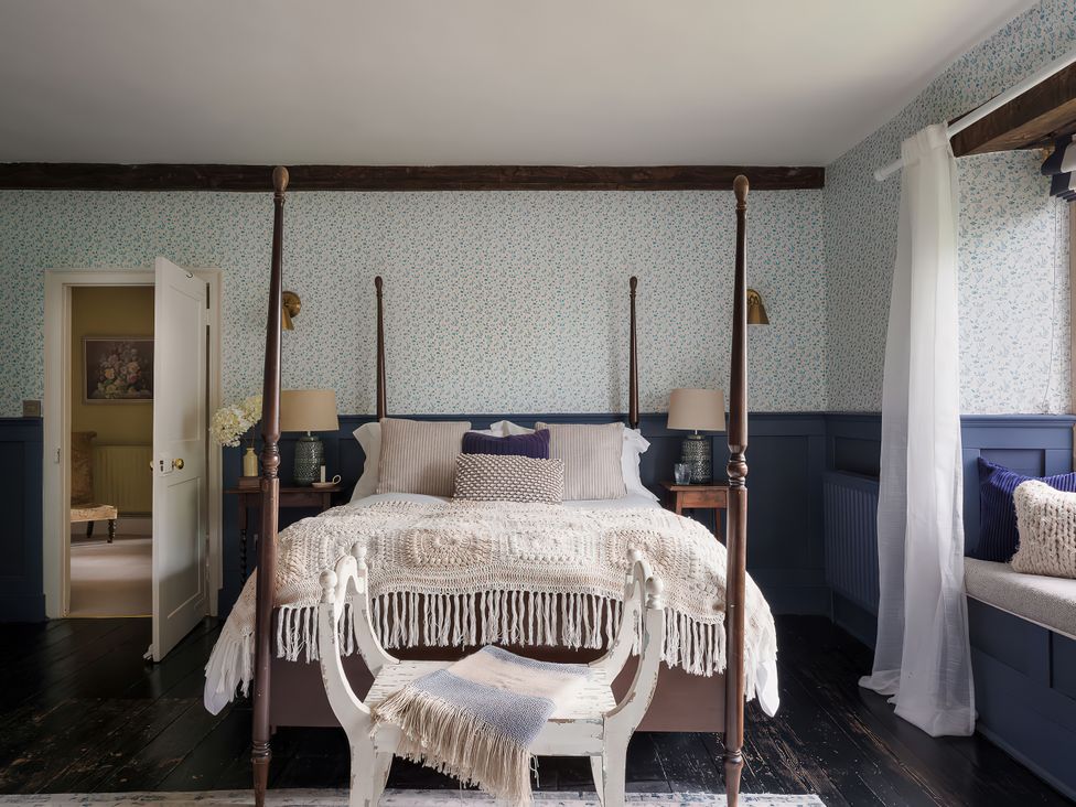 A bedroom with a four-poster bed and window seat at Reybridge House in Lacock
