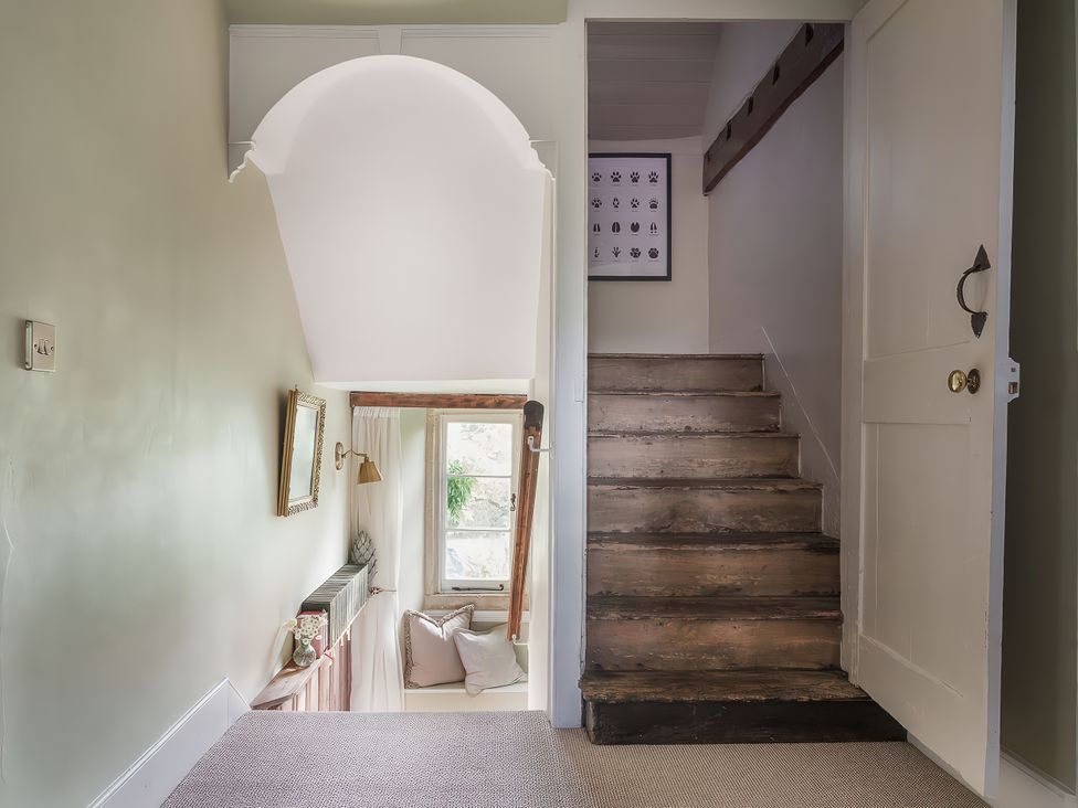 A hallway with a staircase and a window at Reybridge House in Lacock