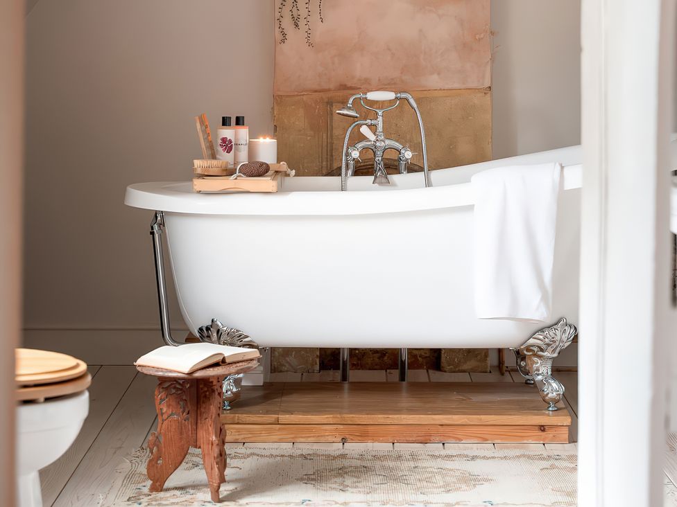 A bathroom with a bathtub and accessories at Reybridge House in Lacock