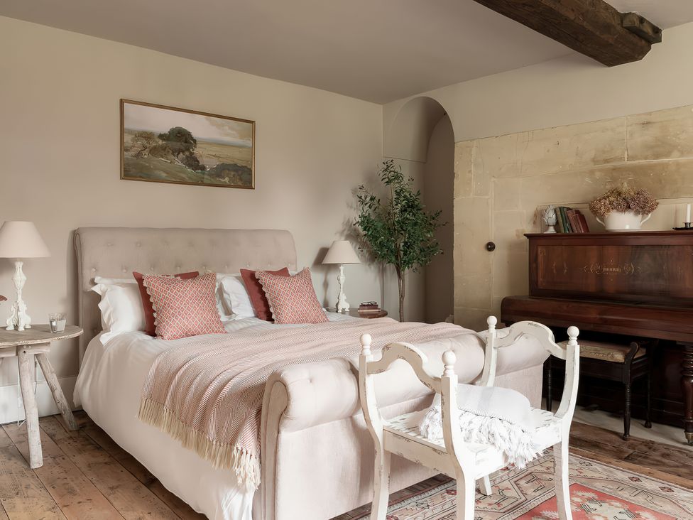 A bedroom with a bed and piano at Reybridge House in Lacock