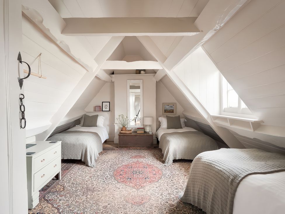 A bedroom with three beds and a mirror at Reybridge House in Lacock