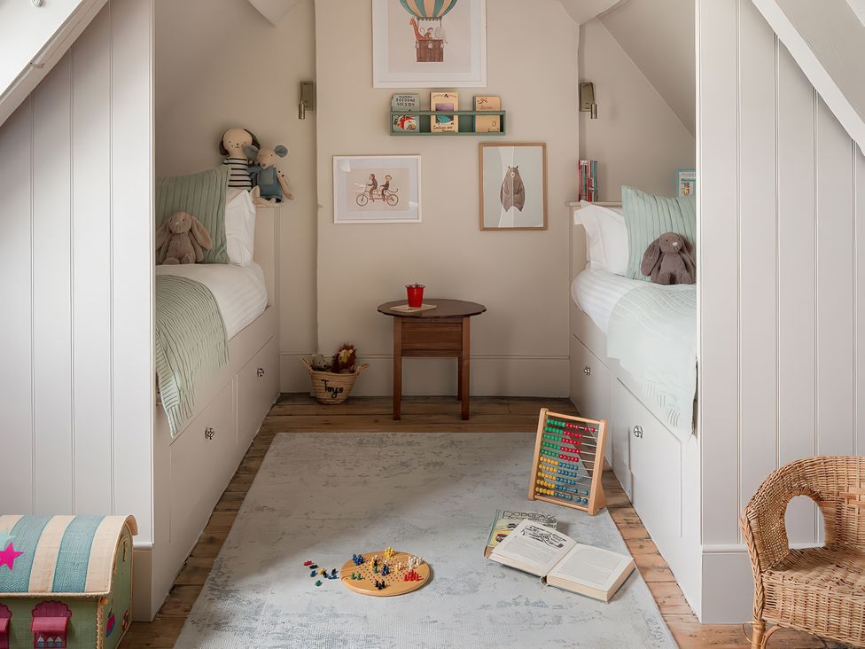 A bedroom with two beds and a table at Reybridge House in Lacock