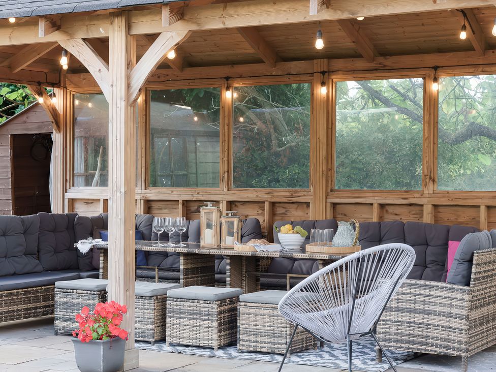 An outdoor seating area with a table and chairs at Reybridge House, Lacock
