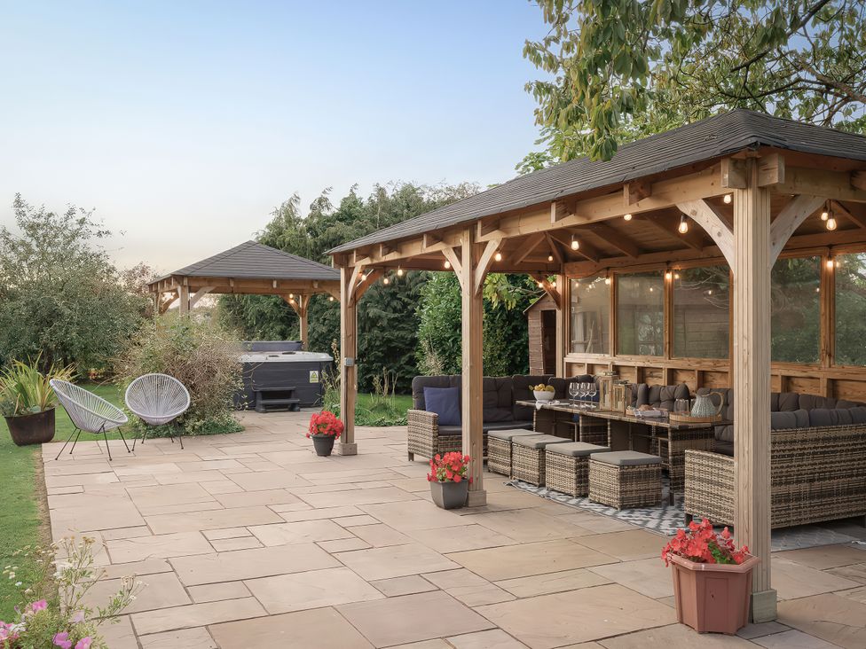 An outdoor patio with a gazebo and hot tub at Reybridge House in Lacock