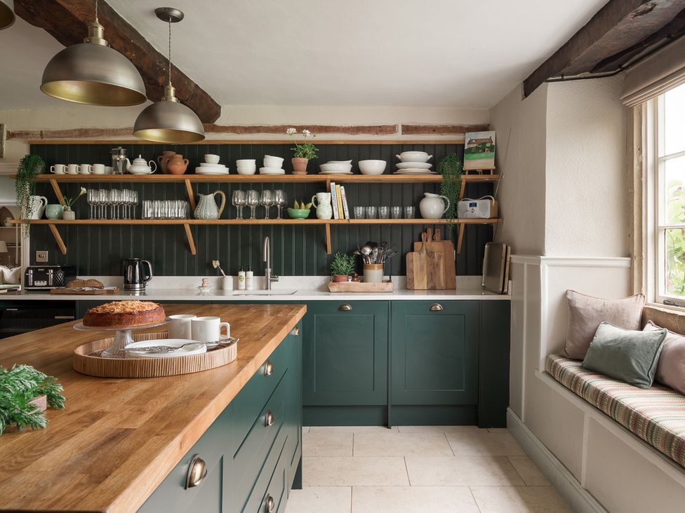 A kitchen with a large island and open shelves at Reybridge House in Lacock