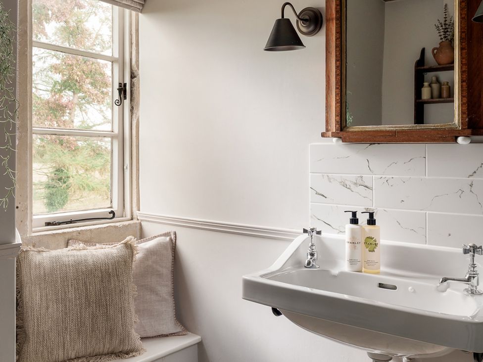 A bathroom with a sink and mirror at Reybridge House Lacock