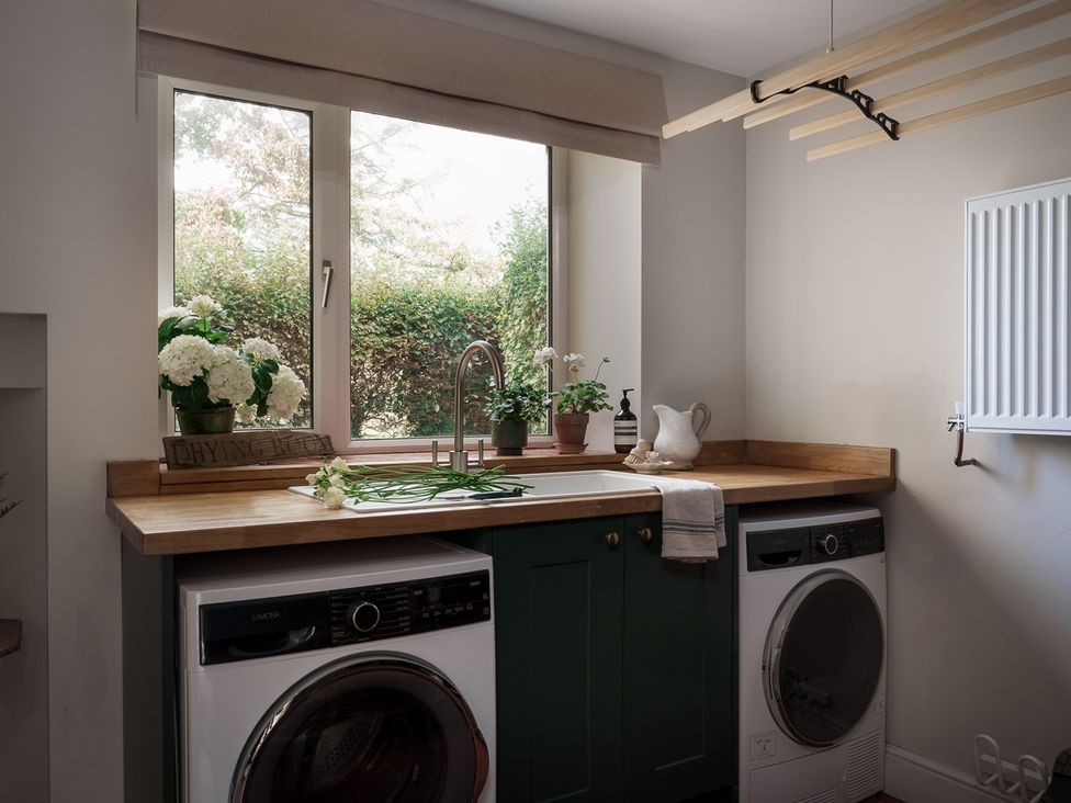 A laundry room with two appliances and plants at Reybridge House in Lacock