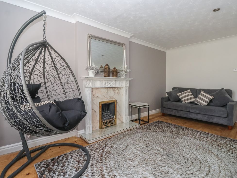A living room with a hanging chair and fireplace at 5 Harebell Close Harrogate