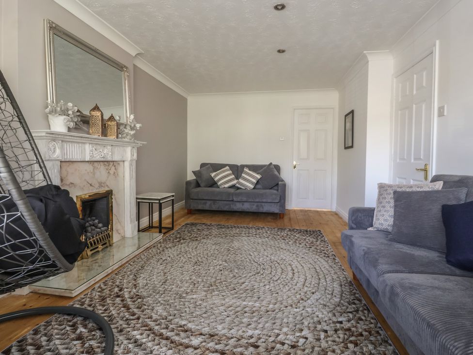 A living room with a fireplace and sofa at 5 Harebell Close Harrogate