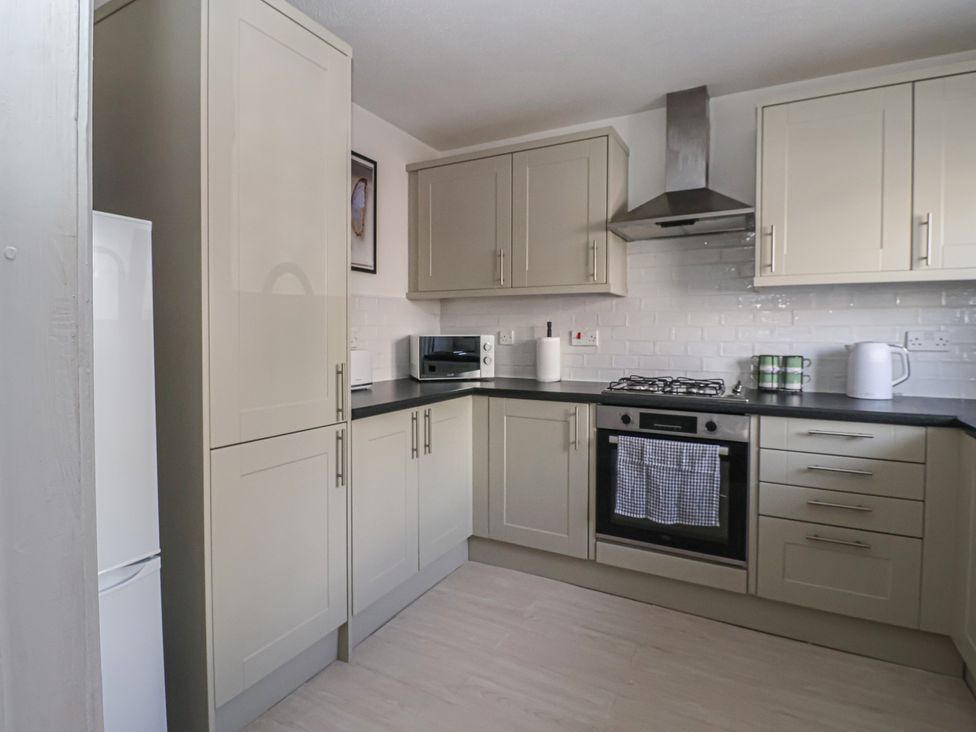 A kitchen with cabinets, oven, and appliances at 5 Harebell Close in Harrogate
