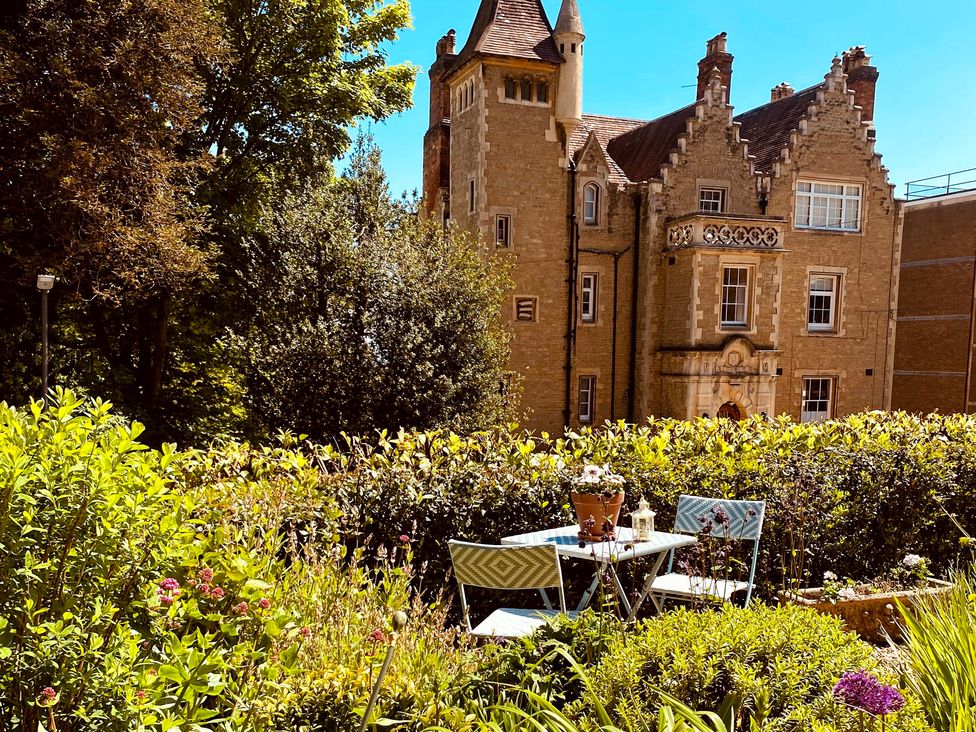 A garden with a table and chairs near a building at The Escape in Malvern