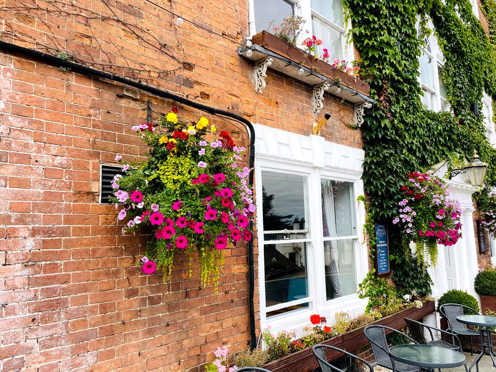 A wall with flower baskets and windows at The Escape Malvern
