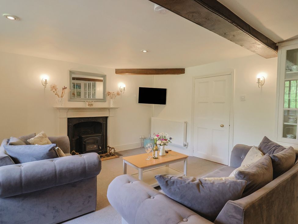 A living room with a fireplace and sofa at Garden View in Wellington