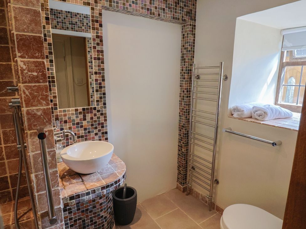 A bathroom with a sink, shower, and towel rack at Garden View in Wellington