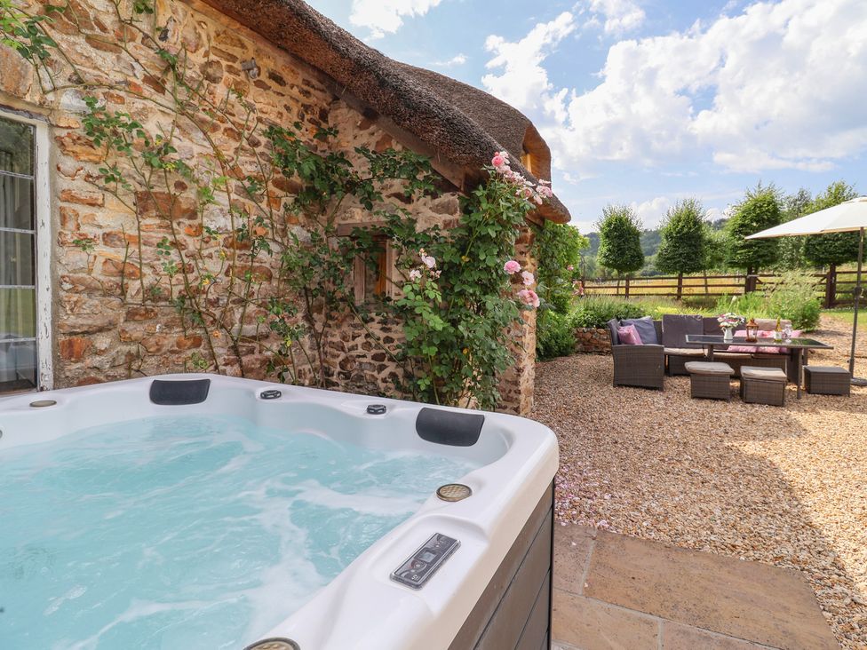 An outdoor area with a hot tub and seating arrangement at Garden View in Wellington
