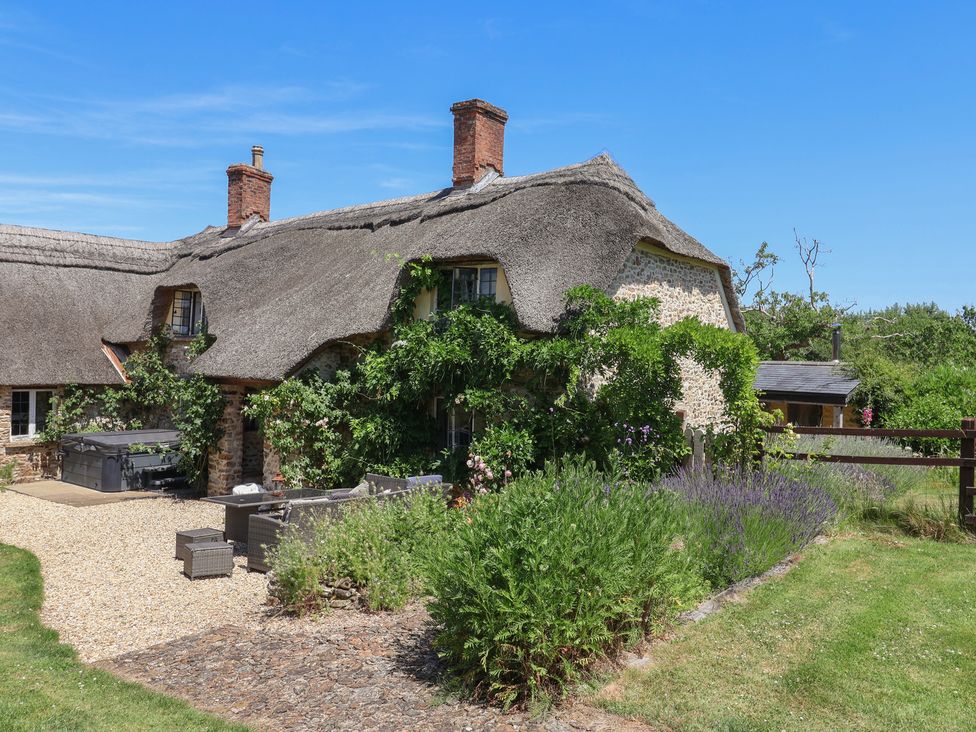 A house with a thatched roof and garden at Garden View in Wellington