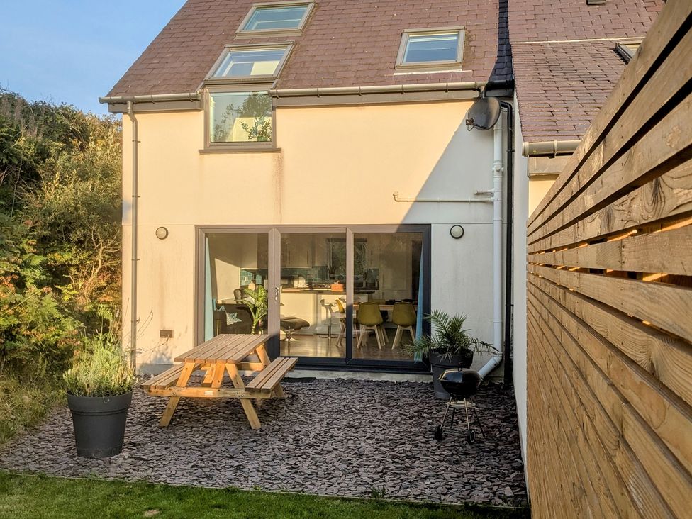 A garden with a picnic table and planter at Hen Gapel Waunfawr, Gwynedd