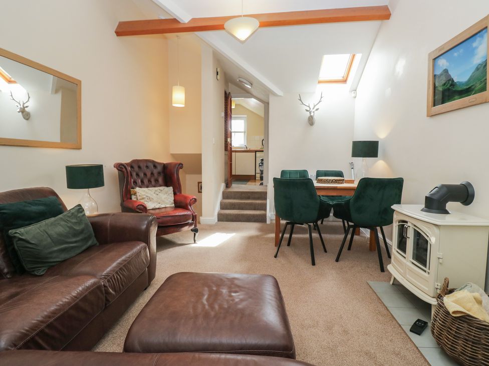 A living room with a sofa and dining area at Walkers Retreat Keswick