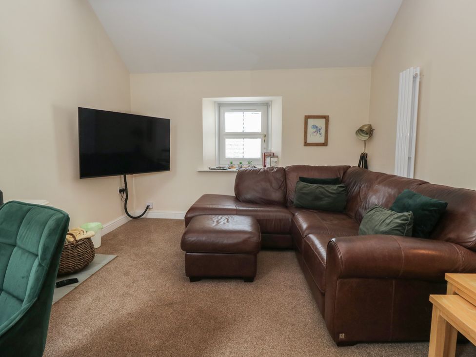 A living room with a sofa and television at Walkers Retreat in Keswick