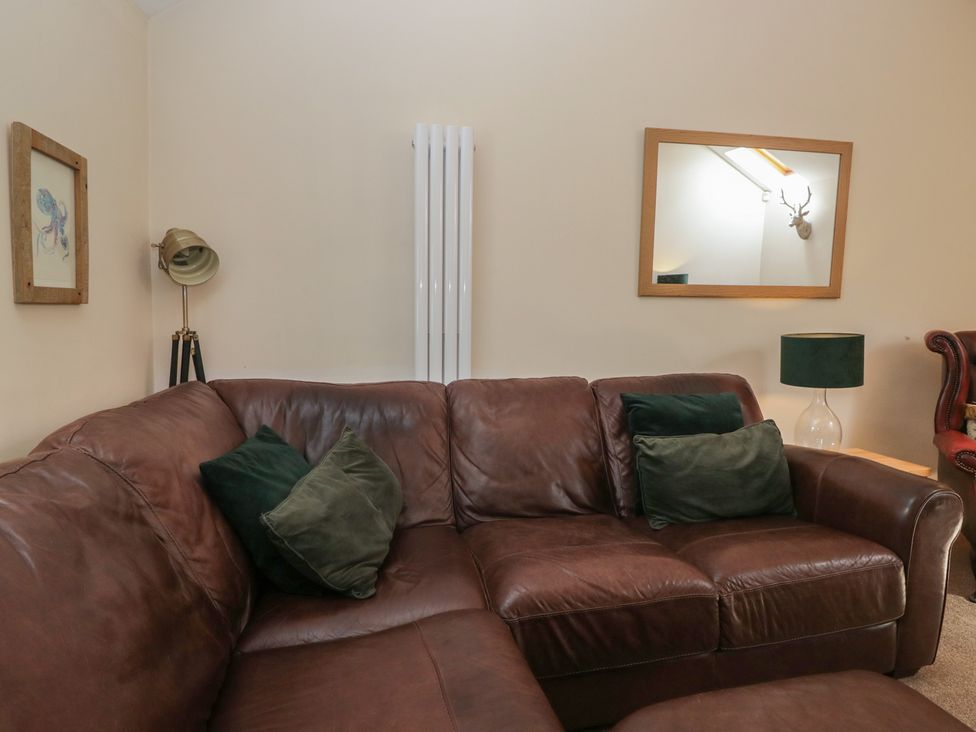 A living room with a brown sofa and decorative items at Walkers Retreat in Keswick