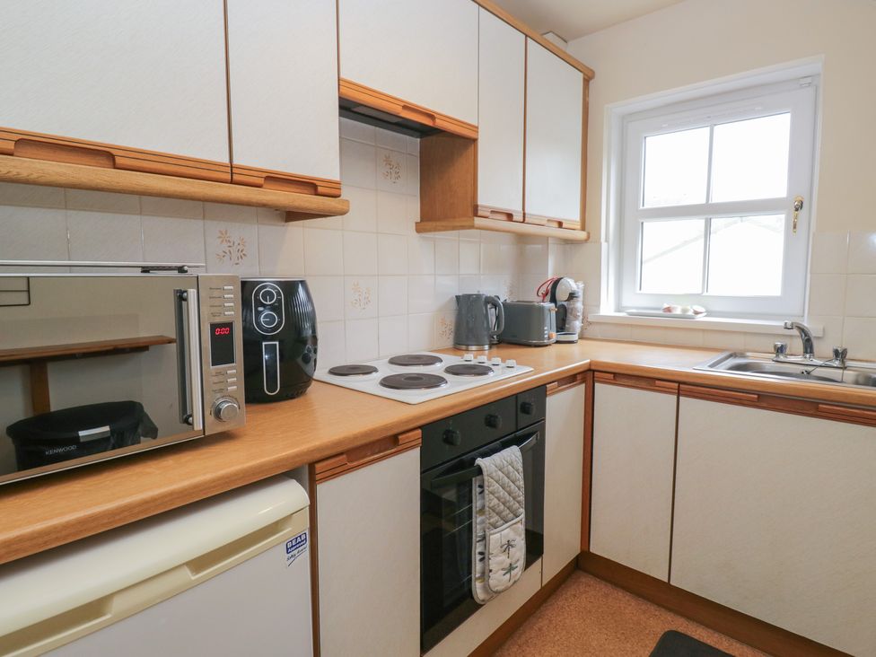 A kitchen with a stove, microwave, and sink at Walkers Retreat in Keswick