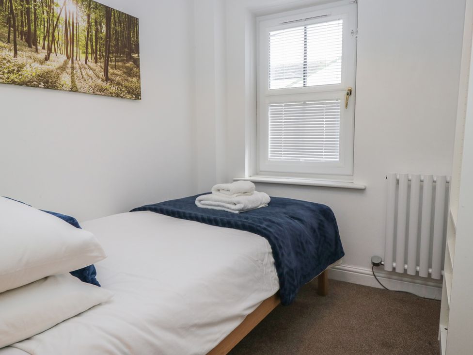 A bedroom with a bed and towels at Walkers Retreat in Keswick