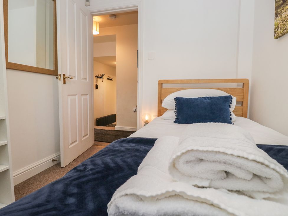 A bedroom with a bed and shelves at Walkers Retreat in Keswick