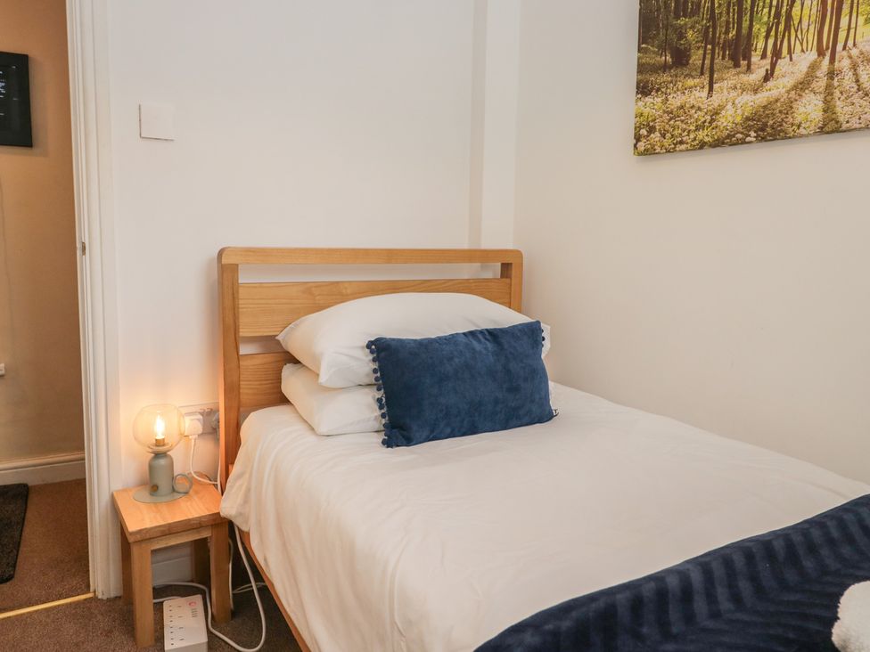 A bedroom with a bed and lamp at Walkers Retreat in Keswick