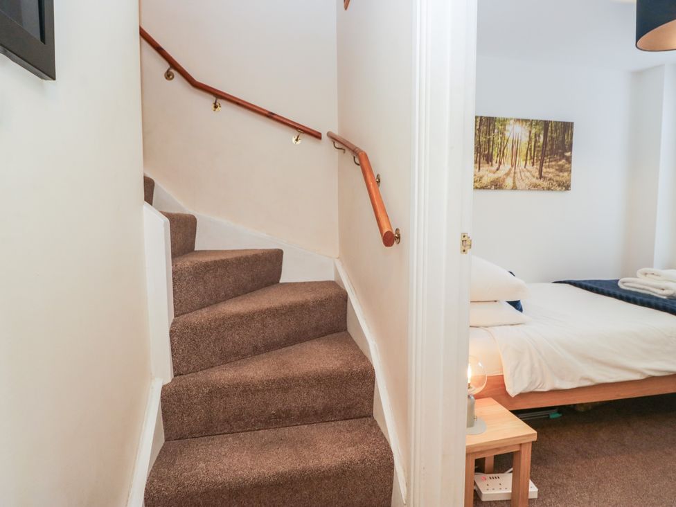 A staircase leading to a bedroom with a bed and lamp at Walkers Retreat in Keswick