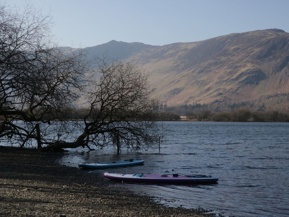 A lake with kayaks and mountains in the background at Walkers Retreat in Keswick