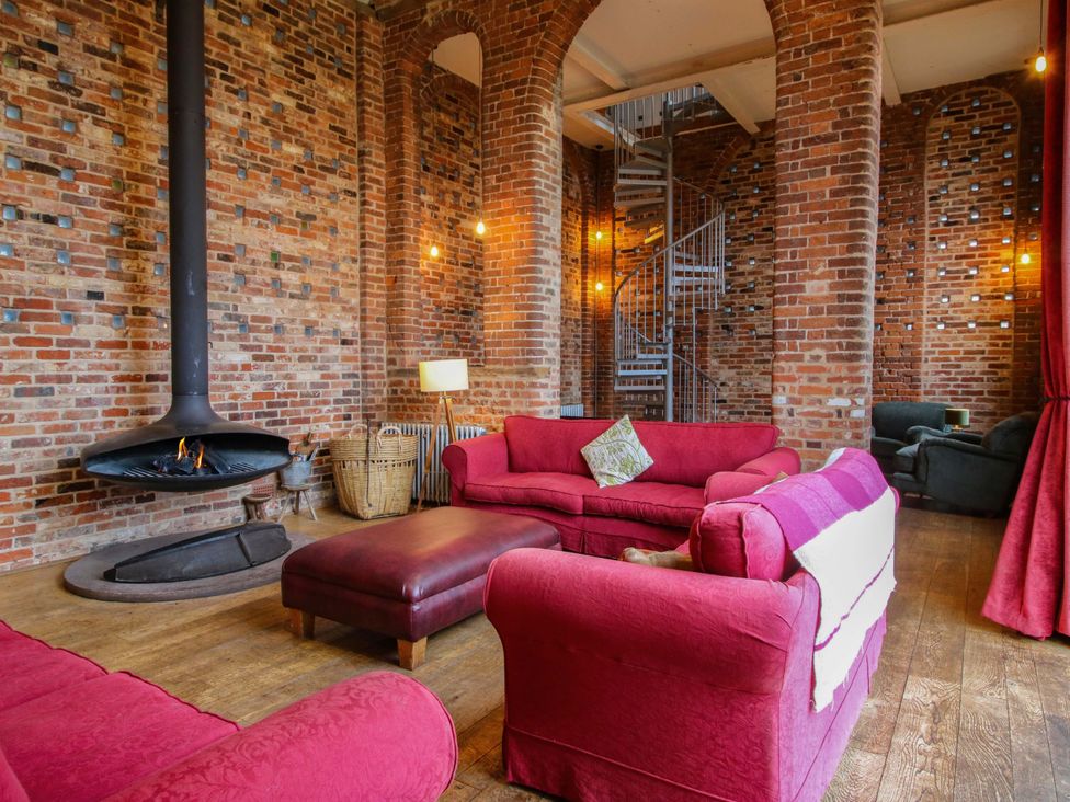 A living room with a fireplace and staircase at Windy Mundy Farm in Pitchford near Shrewsbury