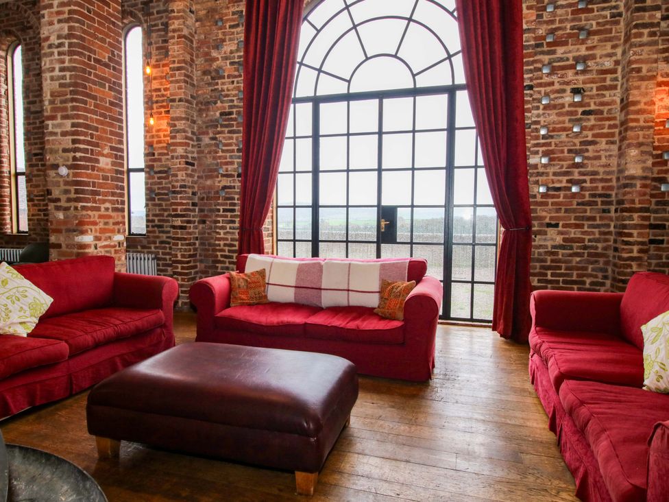 A living room with red sofas and a coffee table at Windy Mundy Farm Pitchford near Shrewsbury