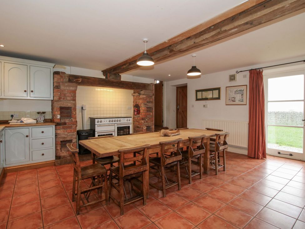A kitchen with a dining table and stove at Windy Mundy Farm in Pitchford near Shrewsbury