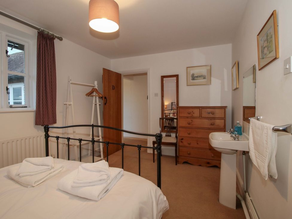 A bedroom with a bed, wardrobe, chair and mirror at Windy Mundy Farm in Pitchford near Shrewsbury