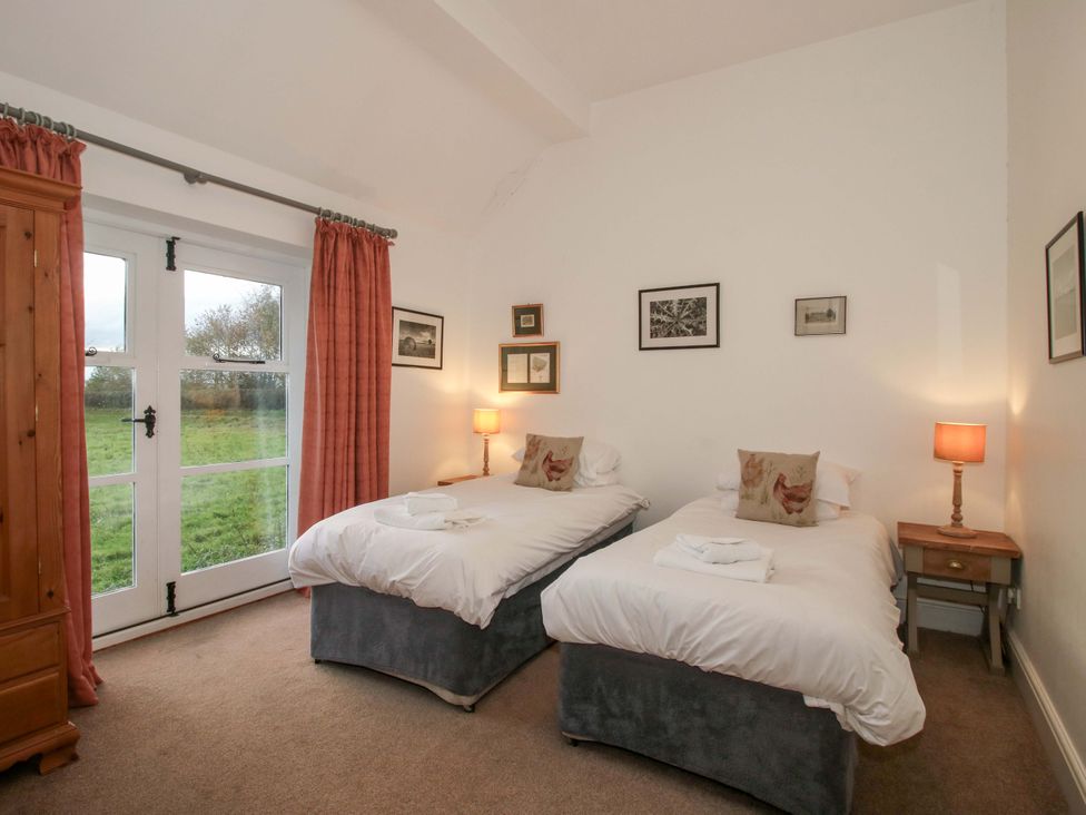 A bedroom with two beds and a wardrobe at Windy Mundy Farm Pitchford near Shrewsbury
