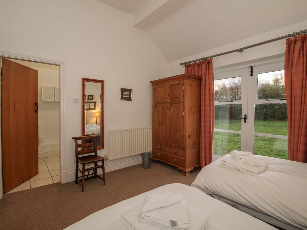 A bedroom with two beds and a wardrobe at Windy Mundy Farm Pitchford near Shrewsbury