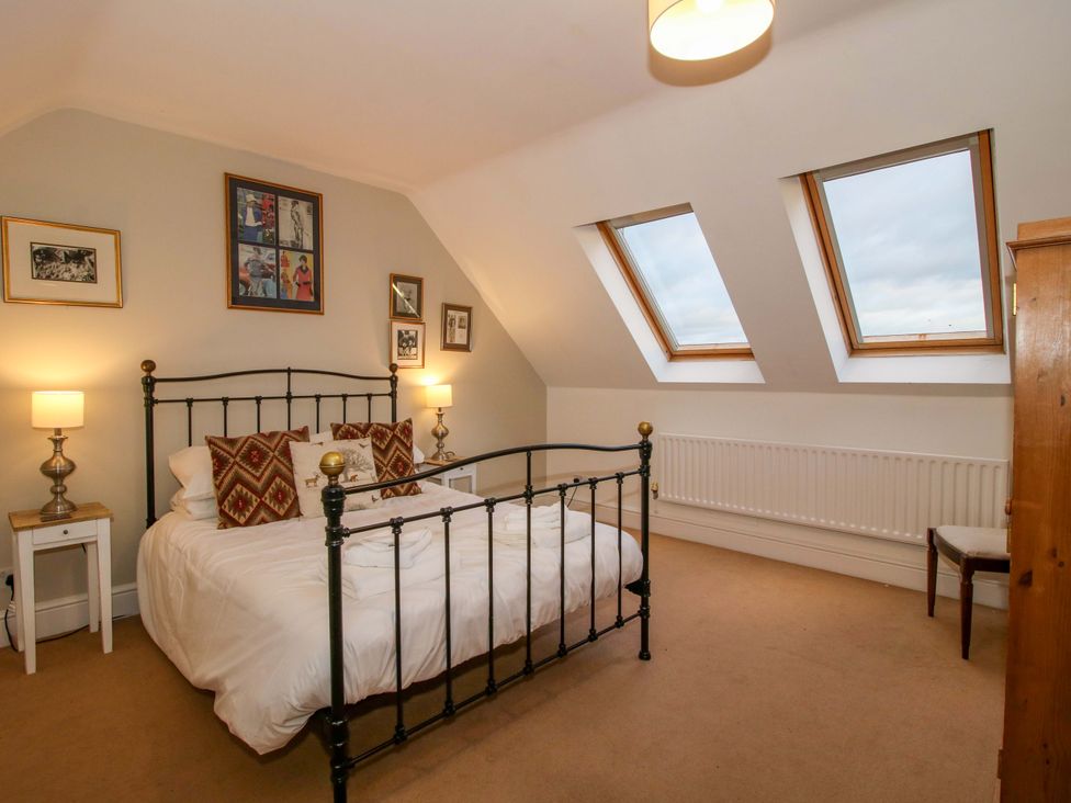 A bedroom with a bed and windows at Windy Mundy Farm in Pitchford near Shrewsbury