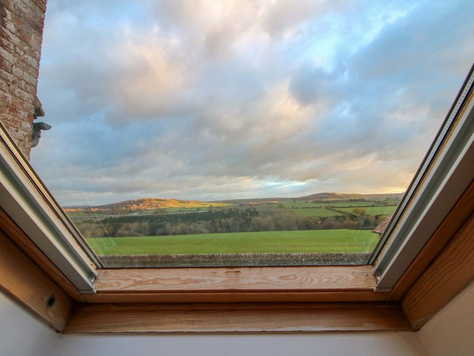 A view from a window overlooking fields and hills at Windy Mundy Farm Pitchford near Shrewsbury