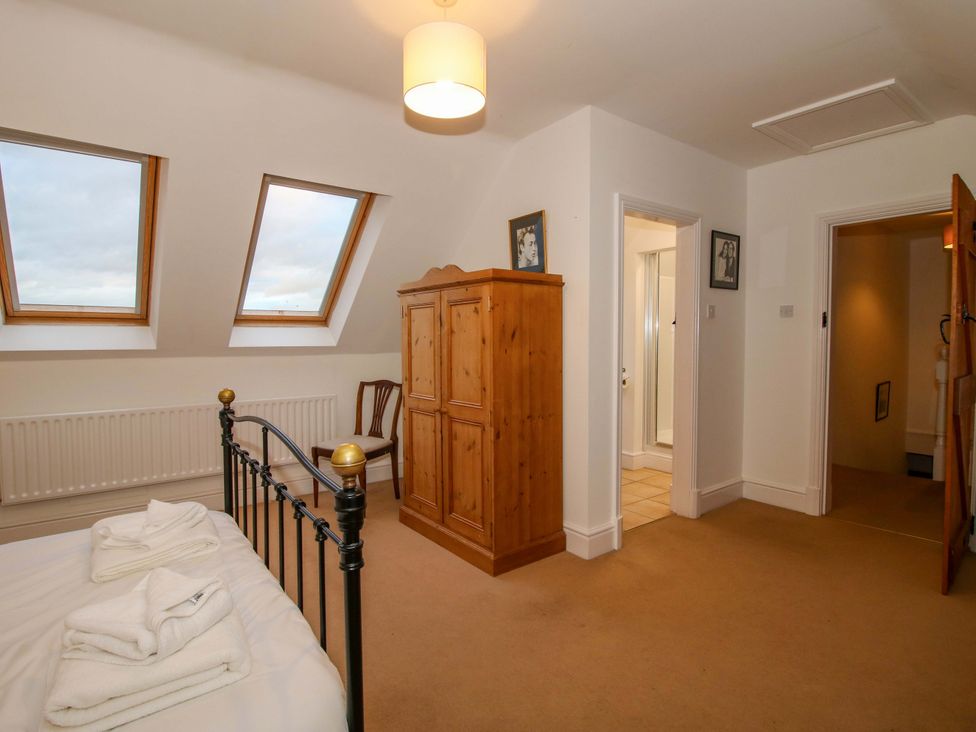 A bedroom with a bed and a wooden wardrobe at Windy Mundy Farm in Pitchford near Shrewsbury