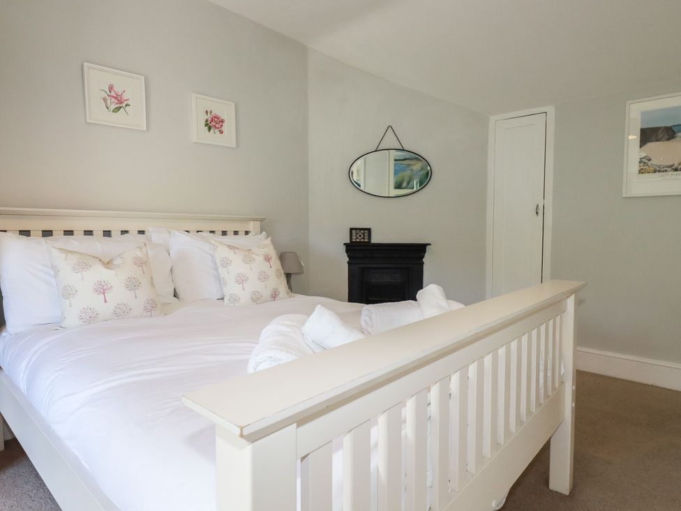 A bedroom with a bed and decor at Trevethen Cottage in Crantock