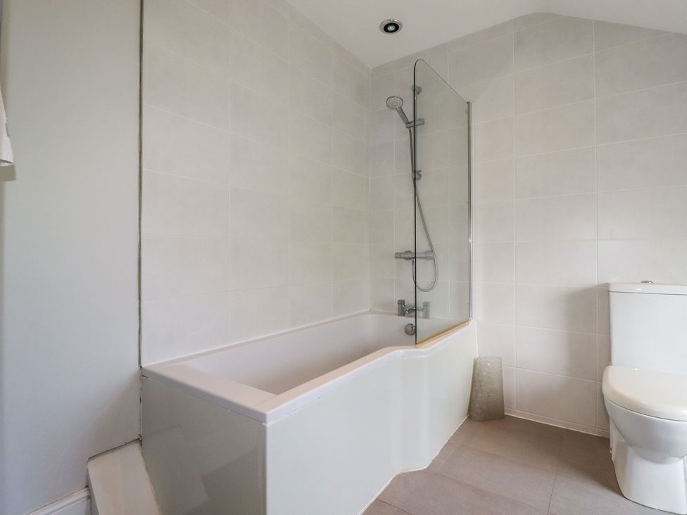 A bathroom with a bathtub and shower at Trevethen Cottage Crantock
