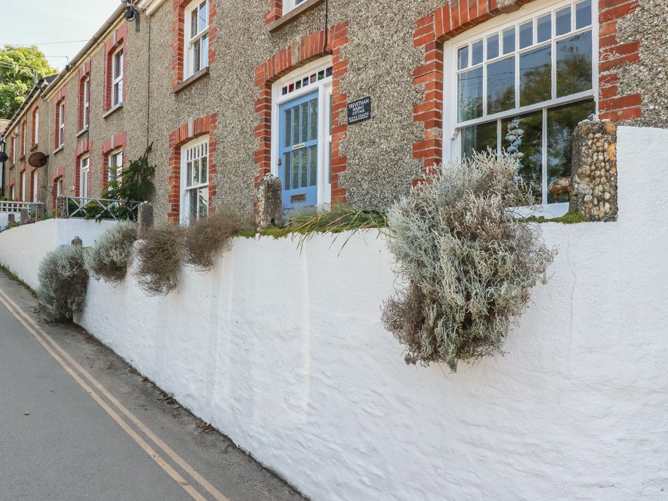 A house with windows and a wall decorated with plants at Trevethan Cottage in Crantock