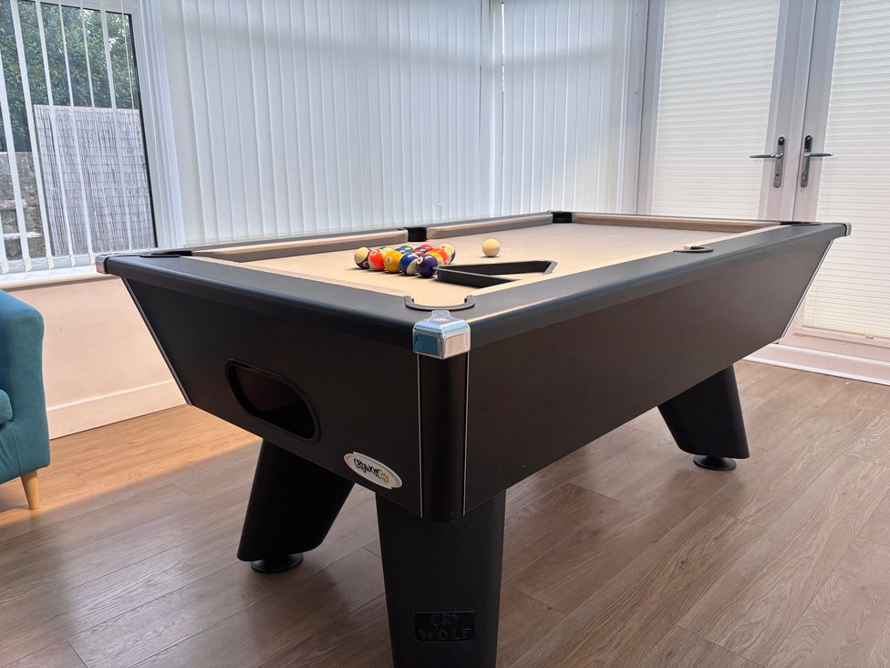 A pool table with balls arranged in a game room at Monarfon in Amlwch