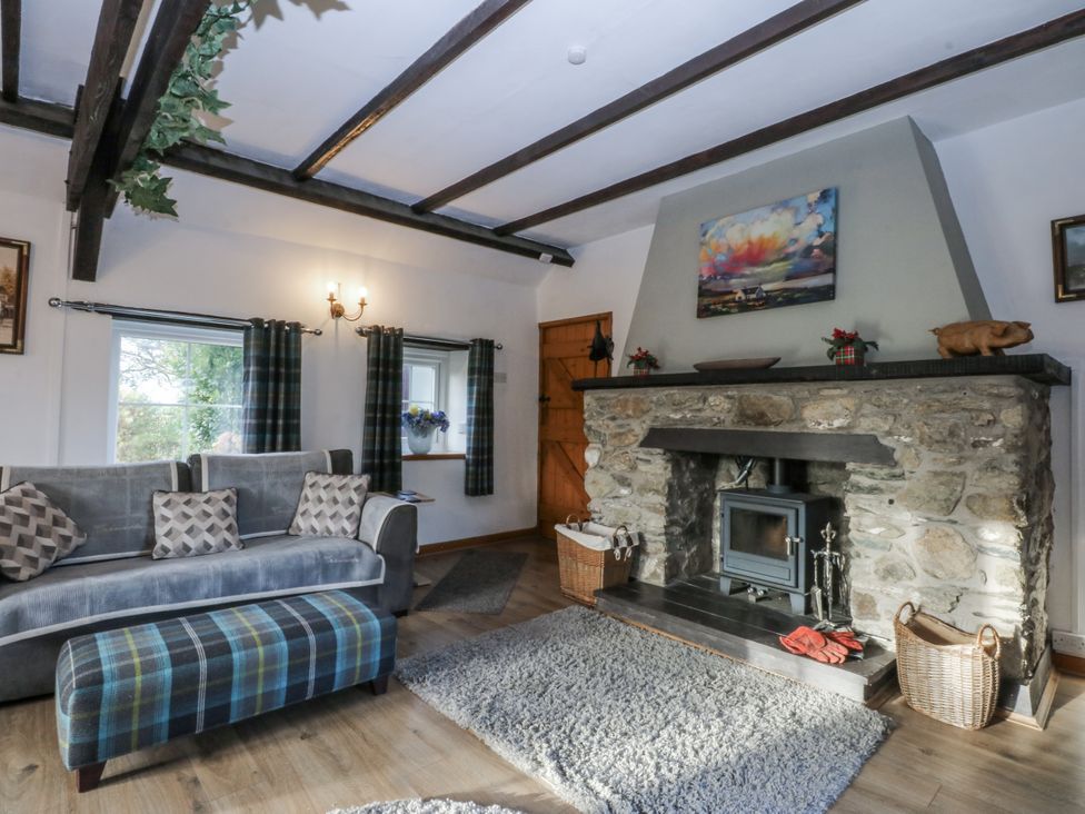 A living room with a fireplace and sofas at Ty Gwennol in Llanfaethlu