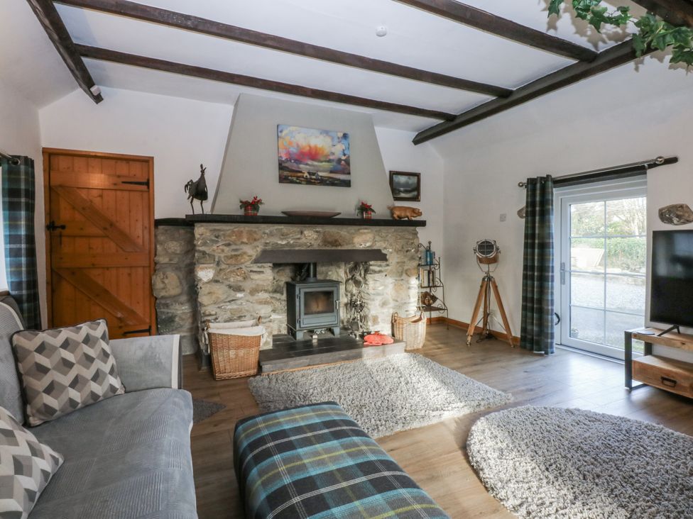 A living room with a fireplace and sofa at Ty Gwennol in Llanfaethlu