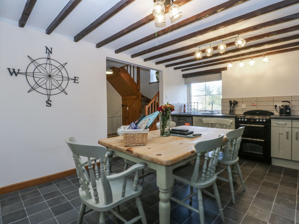 A kitchen with a table and chairs at Ty Gwennol in Llanfaethlu