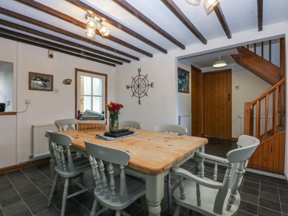 A dining room with a table and chairs at Ty Gwennol in Llanfaethlu