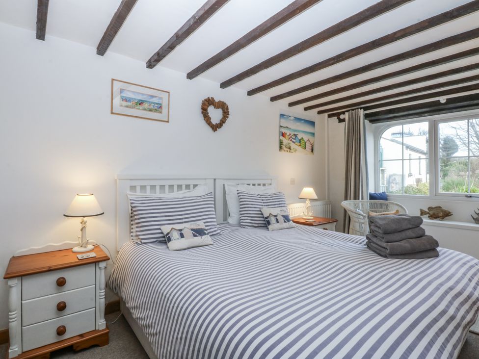A bedroom with a double bed and bedside table at Ty Gwennol in Llanfaethlu
