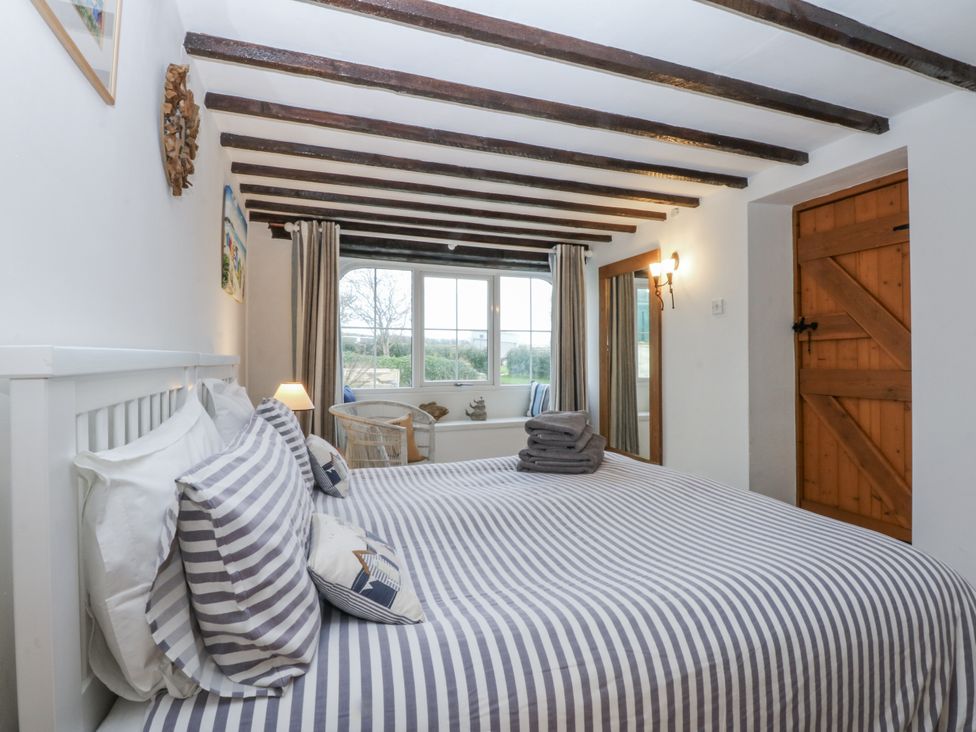 A bedroom with a bed and window at Ty Gwennol in Llanfaethlu